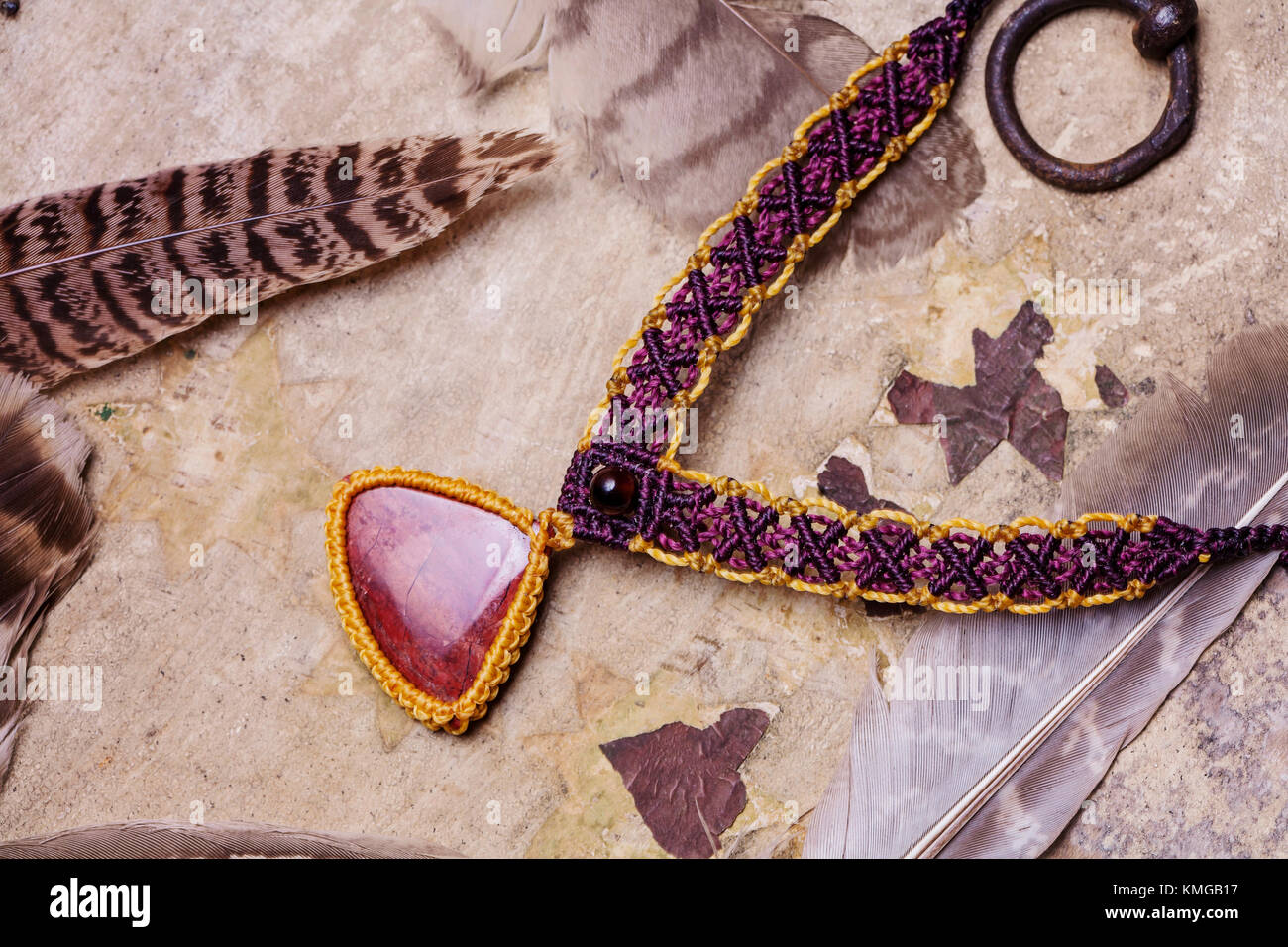 Pietra naturale handmade macrame meterial collana con piuma selvatica sfondo Foto Stock