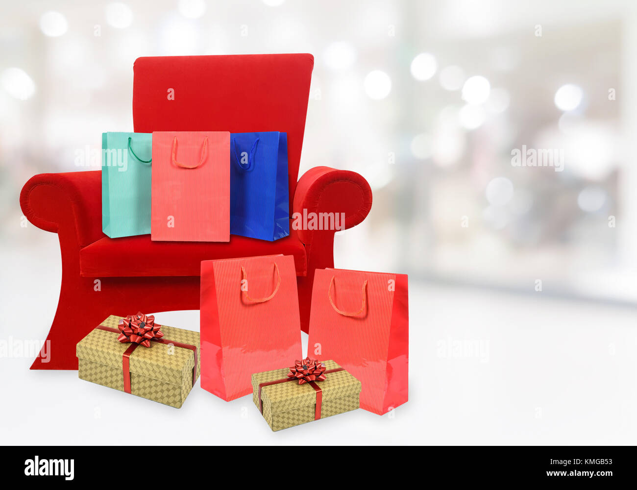 Immagine composita di una poltrona rossa di Babbo Natale con i doni natalizi e spazio di copia sullo sfondo di una offuscata shopping mall interni. Foto Stock