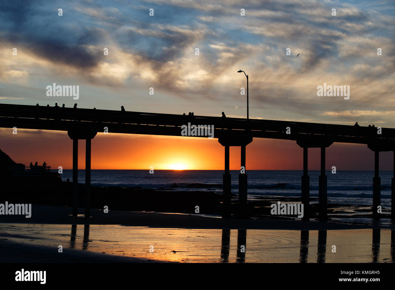 Il set di sole attraverso le nuvole di fumo a San Diego, California's Ocean Beach Pier. Dicembre 7, 2017. Foto Stock