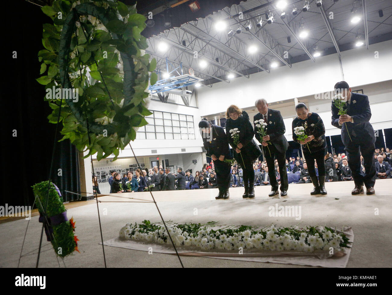 Vancouver. 12 Dic, 2017. I partecipanti fiori di laici durante la cerimonia di lutto di Nanjing massacro ottantesimo anniversario evento commemorativo a Vancouver in Canada. Il 12 Dic. 2017. Circa 400 persone hanno partecipato le vittime' pubblico lutto cerimonia per commemorare l'ottantesimo anniversario del massacro di Nanjing. Credito: Liang Sen/Xinhua/Alamy Live News Foto Stock