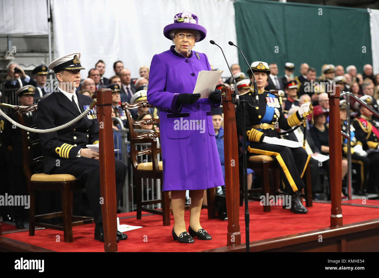 La regina Elisabetta II parla durante la messa in funzione del sistema HMS Queen Elizabeth, la Gran Bretagna è più grande e più potente nave da guerra, nella Royal Navy Fleet a Portsmouth Base Navale. Foto Stock