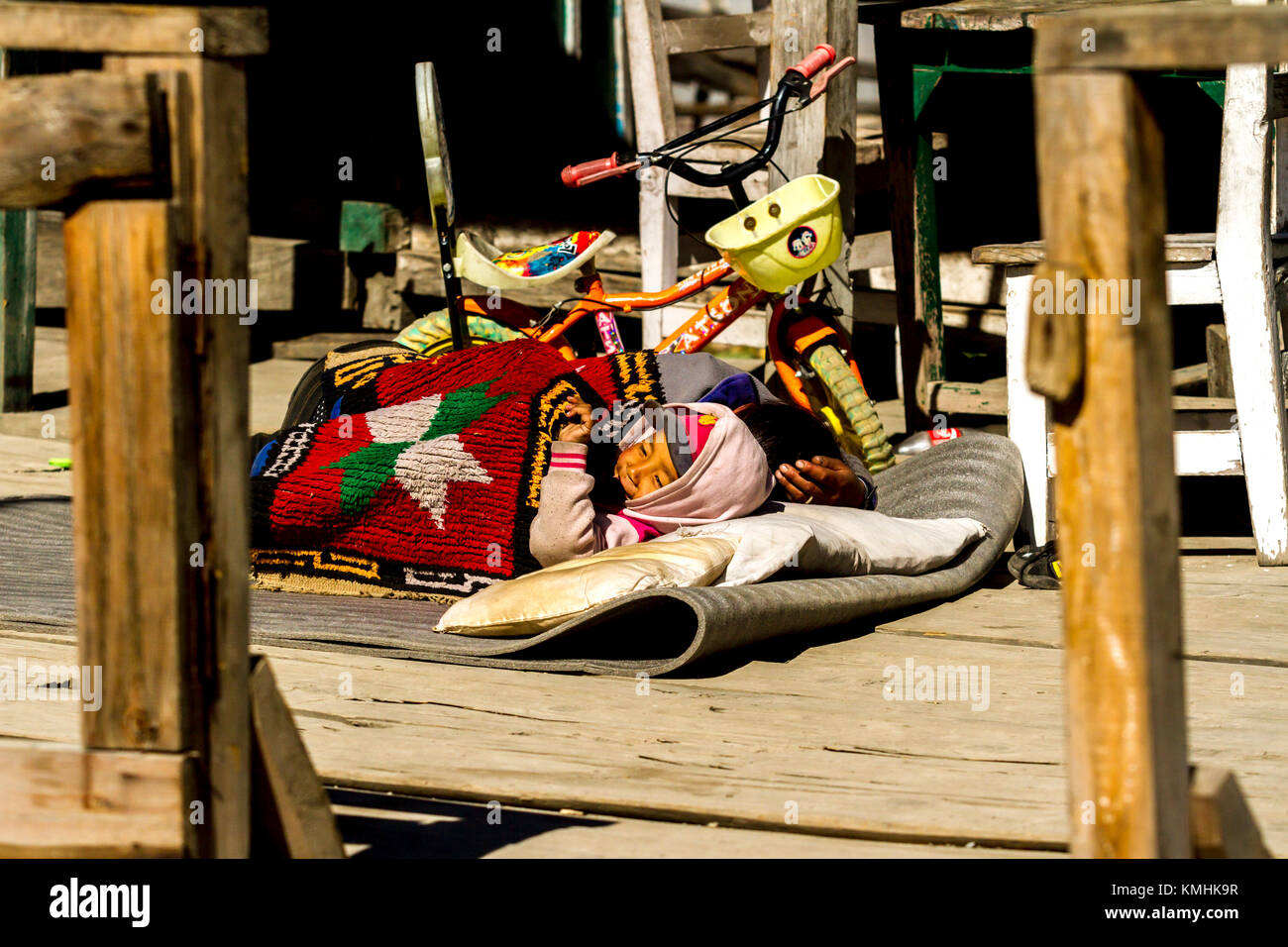 Nepalesi little boy dormire vicino a suo padre. Villaggio di montagna Chame, Nepal, Himalaya Foto Stock