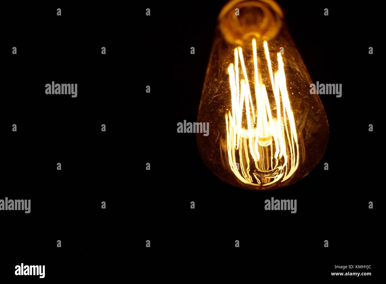 In stile retrò lampadina accesa contro uno sfondo scuro Foto Stock