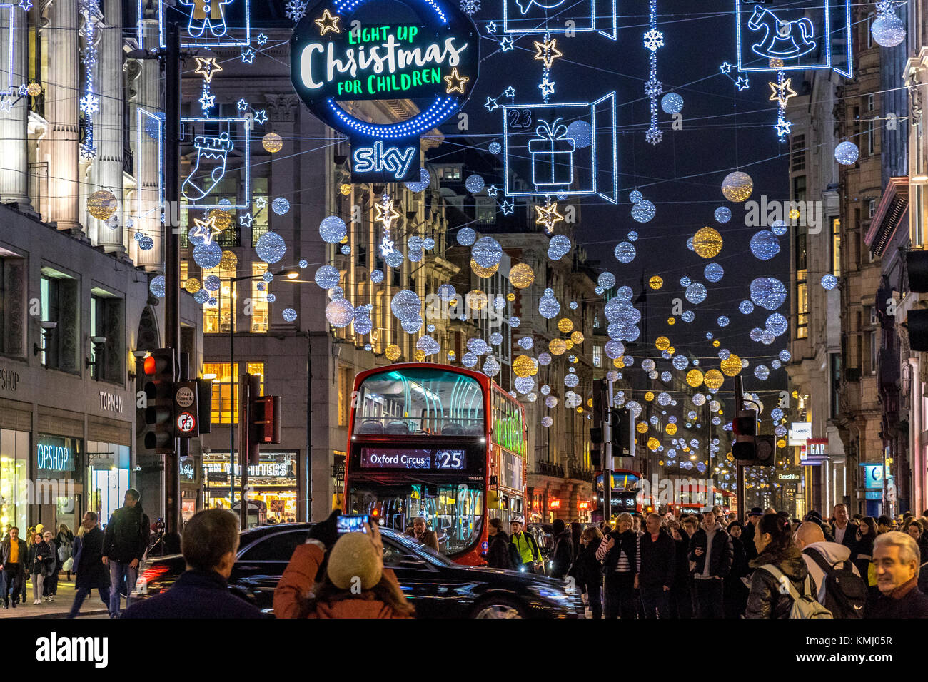 Un autobus No25 lo fa strada lungo Oxford St Londra imballato con i clienti al tempo di Natale sotto le luci di Natale di Oxford St, Londra, Regno Unito Foto Stock