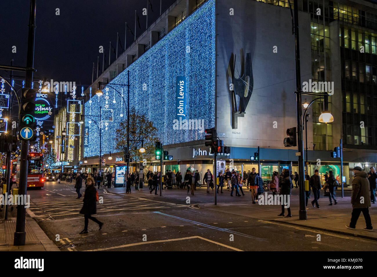 Gli amanti dello shopping natalizio passino accanto al John Lewis Department Store di Oxford Street a Christmas, Londra, Regno Unito Foto Stock