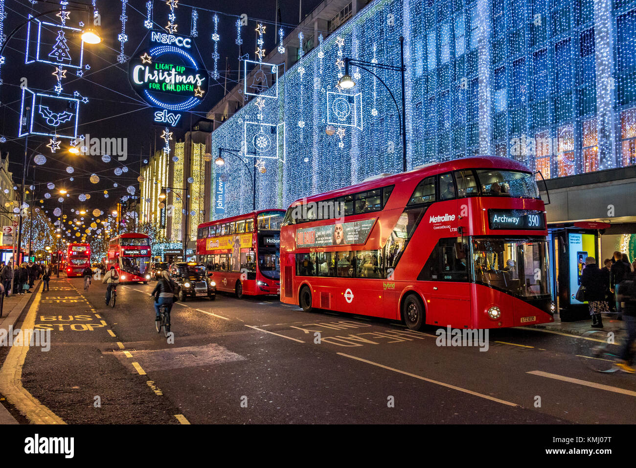 Gli autobus di Londra si allineano fuori dal grande magazzino John Lewis su Oxford St di Londra al tempo di Natale sotto l'Oxford St Christmas Lights.London, Regno Unito Foto Stock