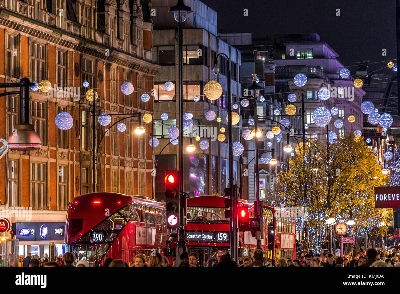 Le decorazioni di Natale di Oxford St con gli autobus di Londra, a Natale imballato con i clienti di Natale che camminano lungo Oxford St, Londra, Regno Unito Foto Stock