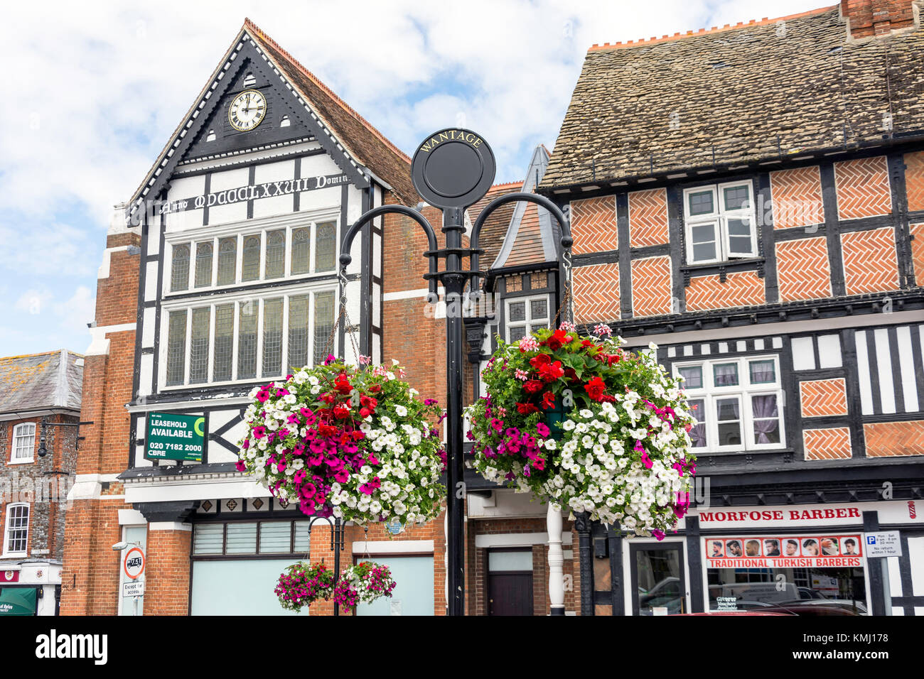 Edifici del periodo e cesti di fiori, Market Place, Wantage, Oxfordshire, England, Regno Foto Stock