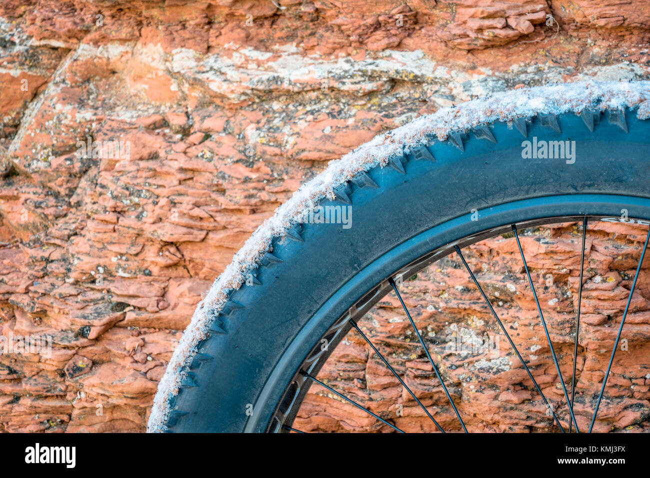 Fat bike ruote coperte da polvere, il fango e la neve di arenaria contro la parete del canyon Foto Stock