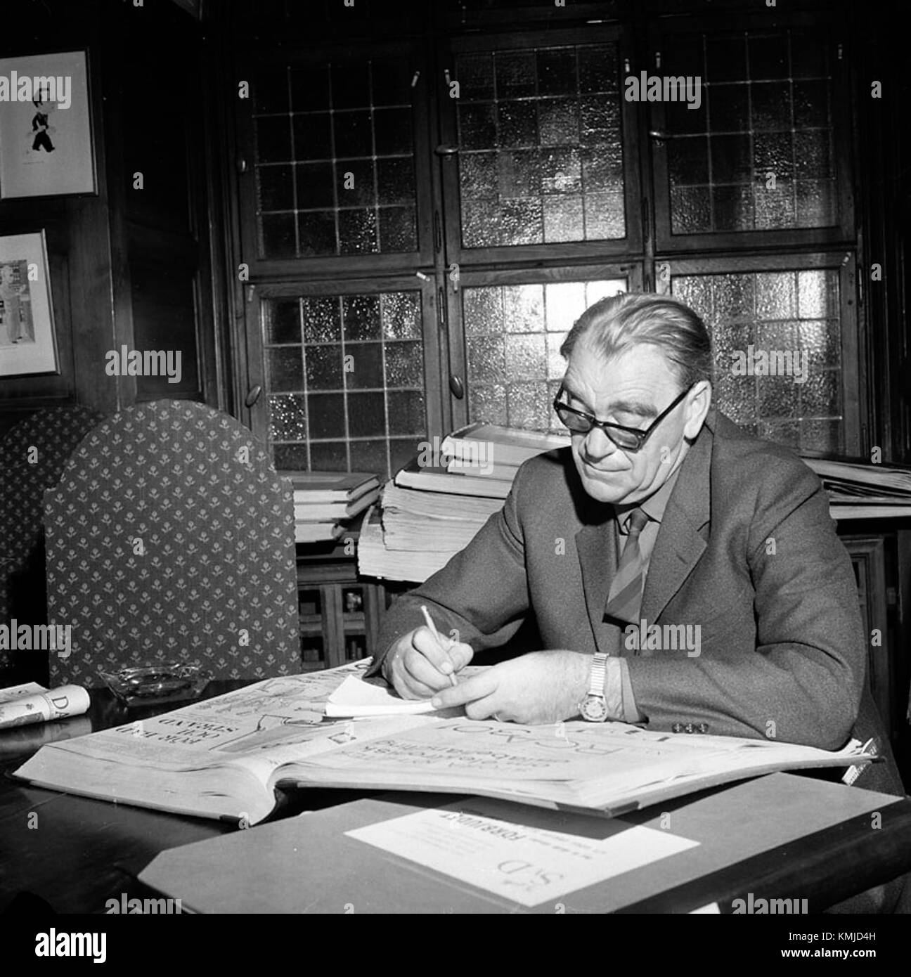 Vilhelm Moberg, il famoso autore svedese, è raffigurato leggendo Svenska Dagbladet, che riflette il suo impegno con gli eventi contemporanei e il suo ruolo nella cultura letteraria svedese. Foto Stock