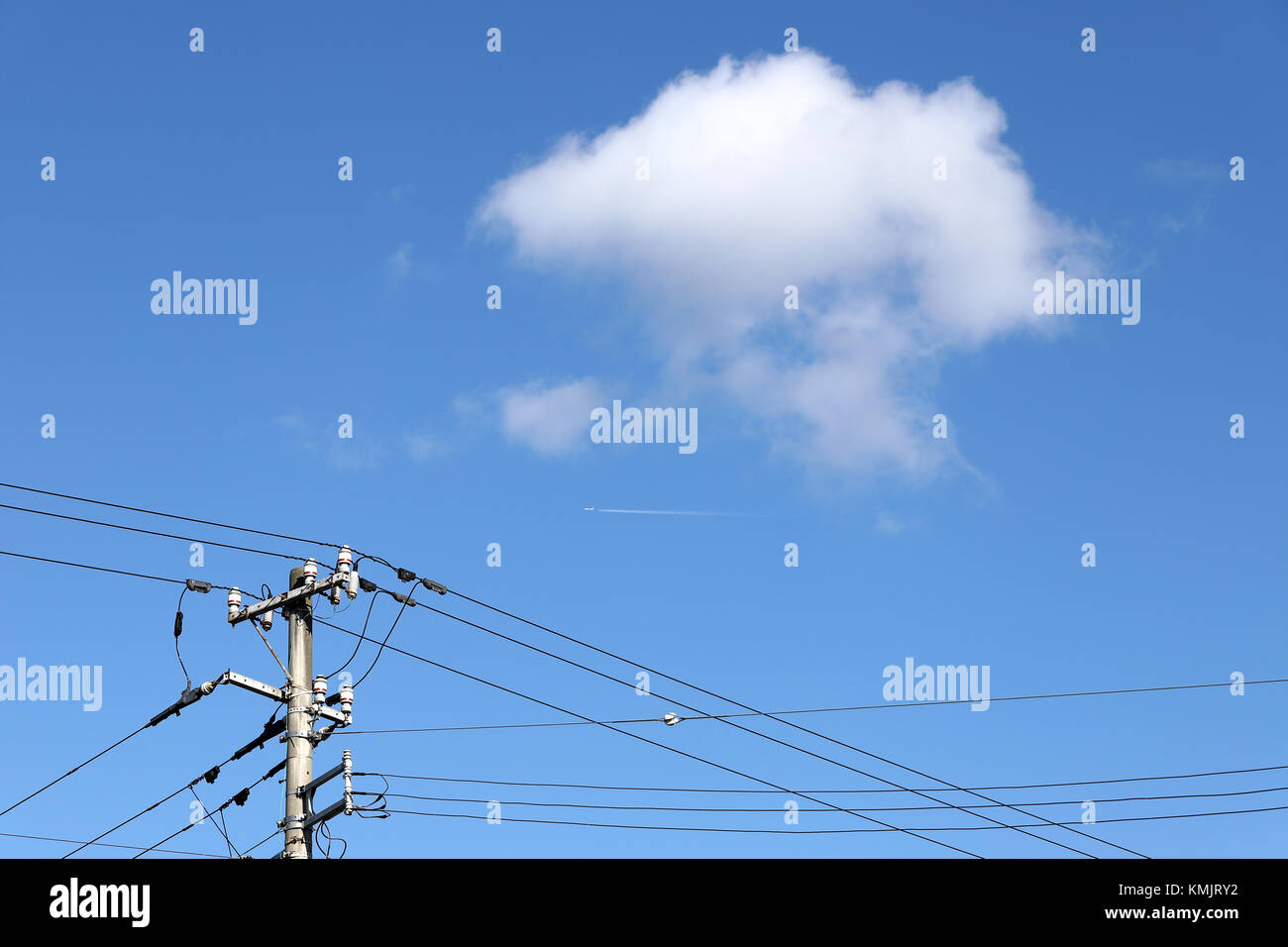 Elettricità post contro un cielo blu con nuvole Foto Stock