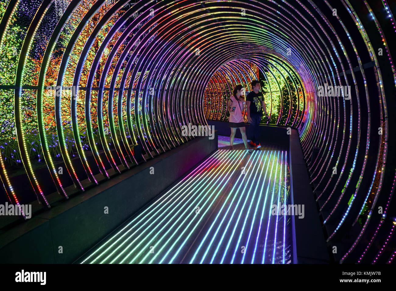 Uomo e donna che cammina nel percorso di LED a 'itinerario universale" presso gli Universal Studios di Singapore. Foto Stock