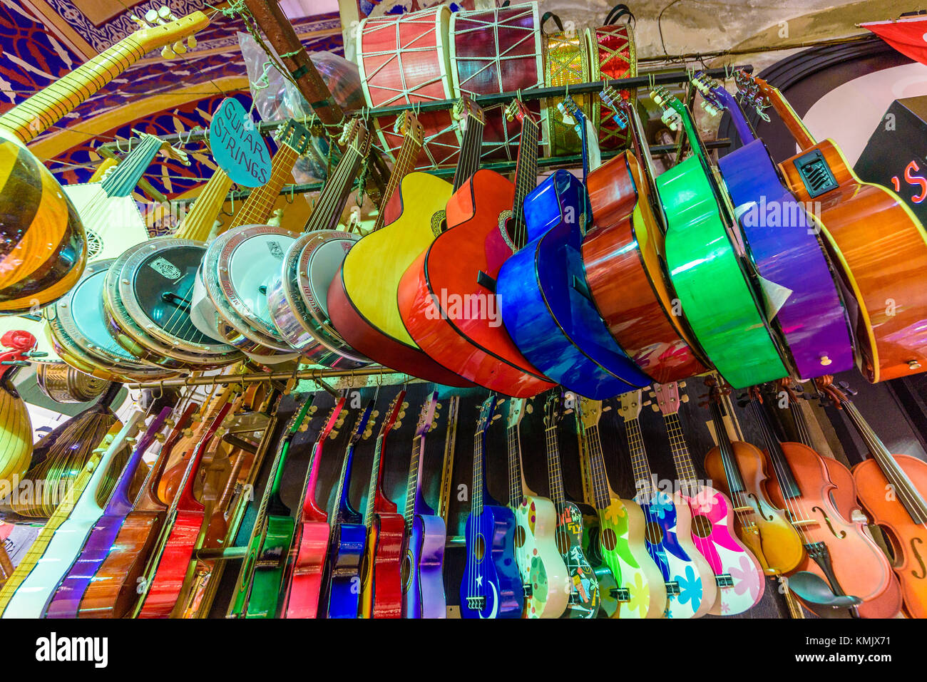 Molti classici in legno colorato chitarre appeso alla parete in store showroom, la configurazione di sfondo in Istanbul grand bazaar Foto Stock