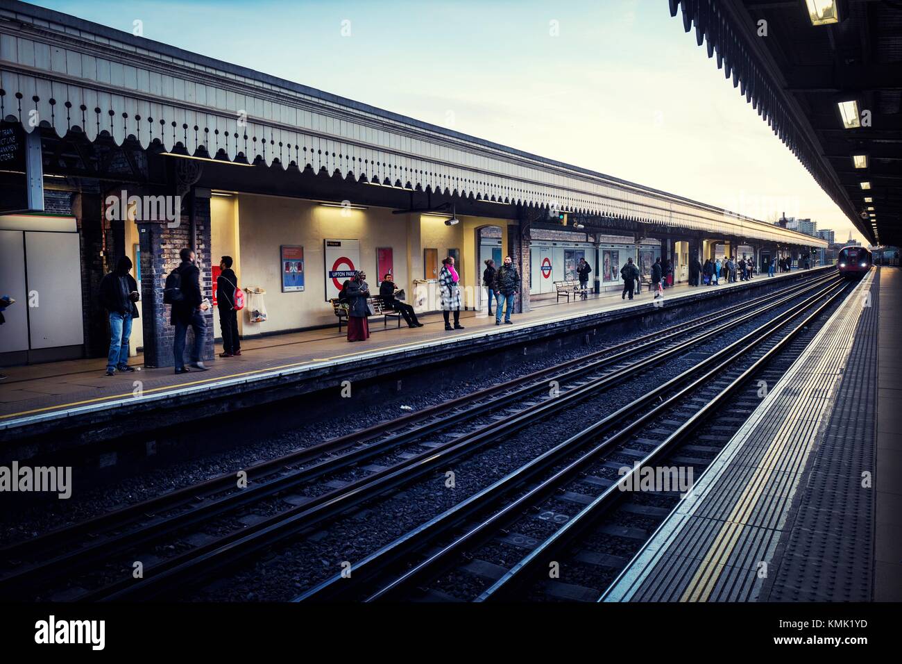 Persone nella piattaforma della stazione metropolitana di Upton Park. Upton Park, East London, London, England, Regno Unito Foto Stock