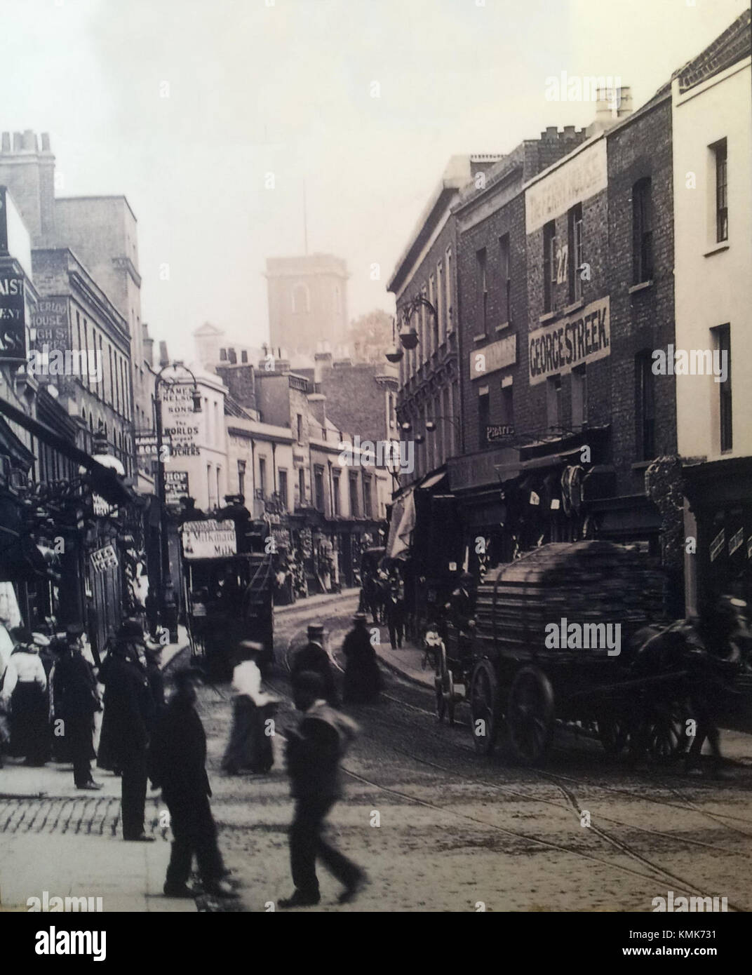 Questa immagine storica raffigura Woolwich High Street a Londra, una posizione significativa all'interno della città conosciuta per il suo commercio e i collegamenti con i mezzi di trasporto. L'area è stata una parte fondamentale dello sviluppo di Londra per secoli. Foto Stock