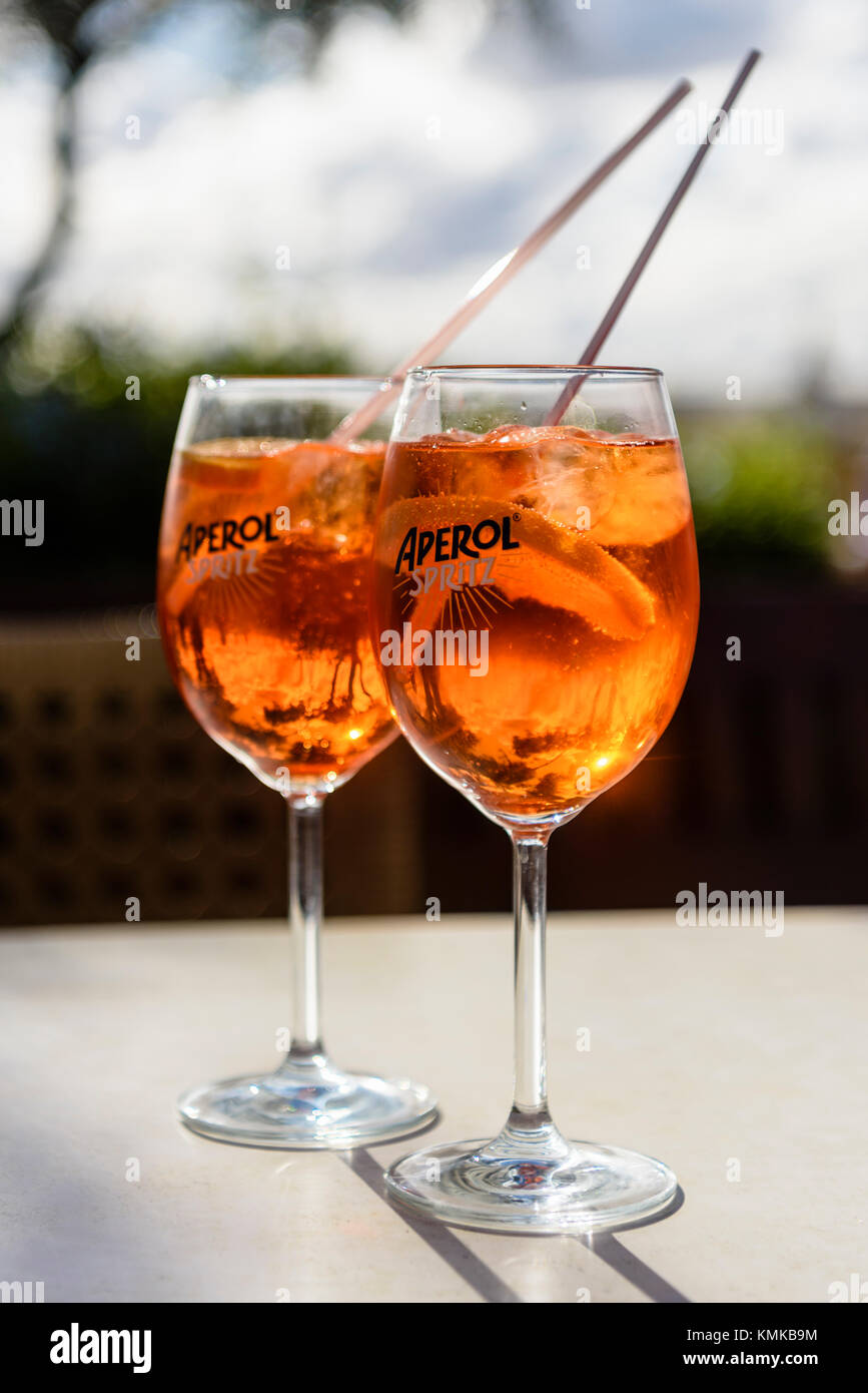 Due bicchieri di Aperol Spritz, una miscela di Aperol, Prosecco e acqua di soda con Orange, su un tavolo in un bar esterno. Foto Stock