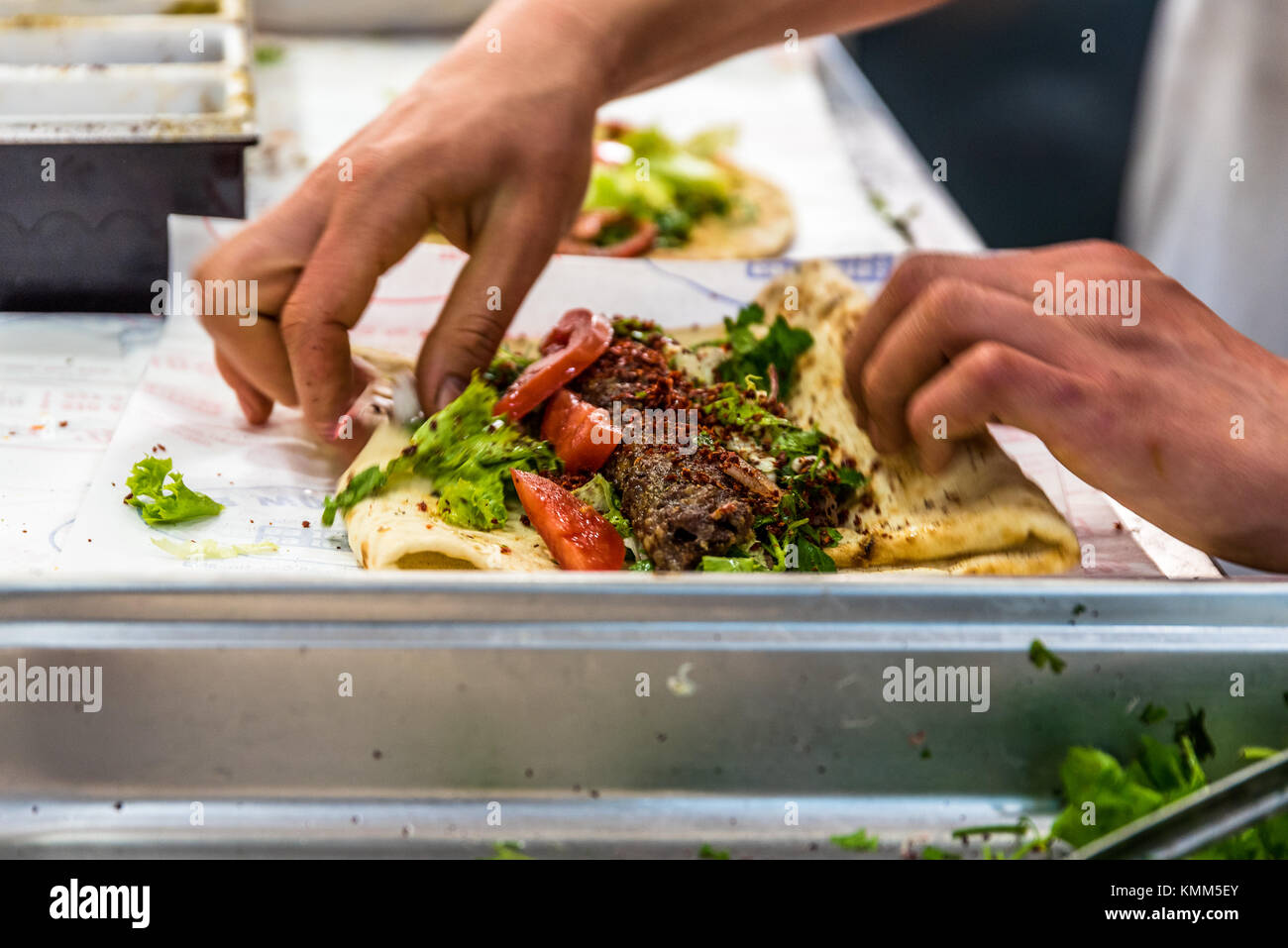 Man mano preparare deliziose grigliate turco di fegato shish kebab oltre il lavash per servire. Foto Stock