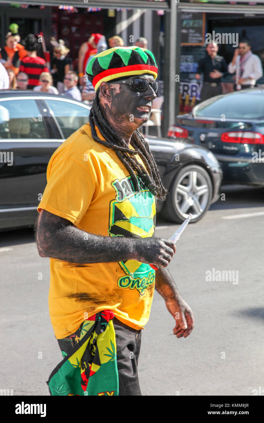 Benidorm città nuova British fancy dress giorno persona vestita come rastafarian uomo con splif Foto Stock