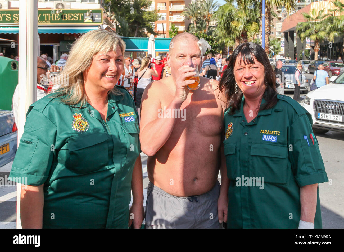 Benidorm città nuova British fancy dress giorno persone vestite come paramedici con uomo ferito boozing Foto Stock