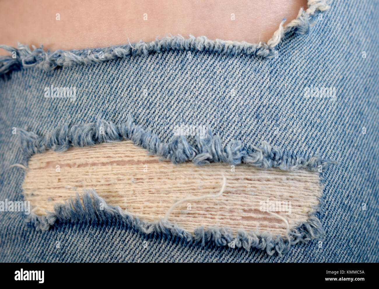 Jeans strappati con gamba che mostra la pelle Foto Stock