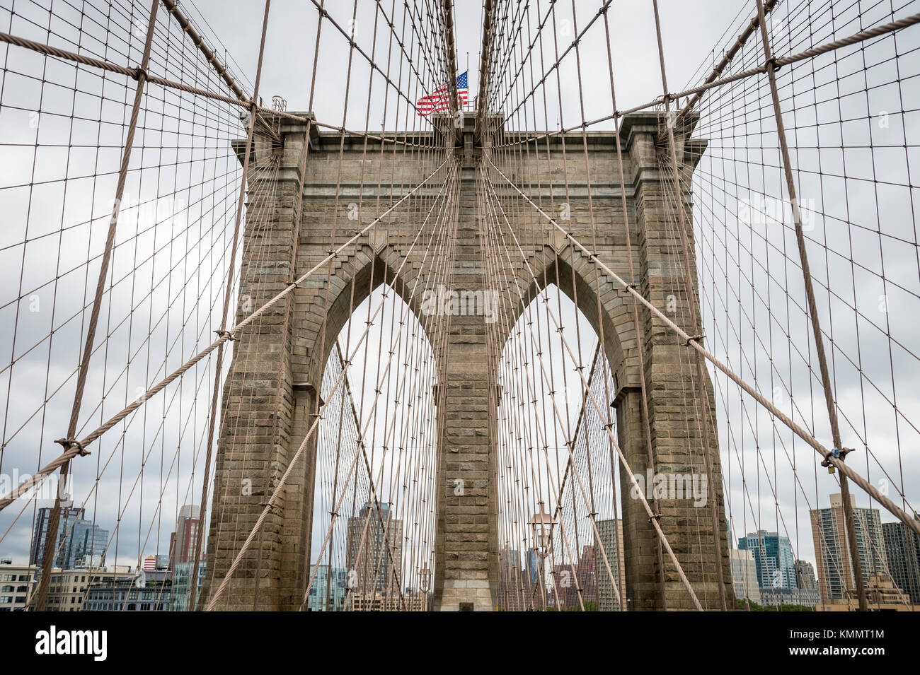 Close up dettagli architettonici del cavo di acciaio patterns che conduce al tradizionale torre in pietra del ponte di Brooklyn a New York City Foto Stock
