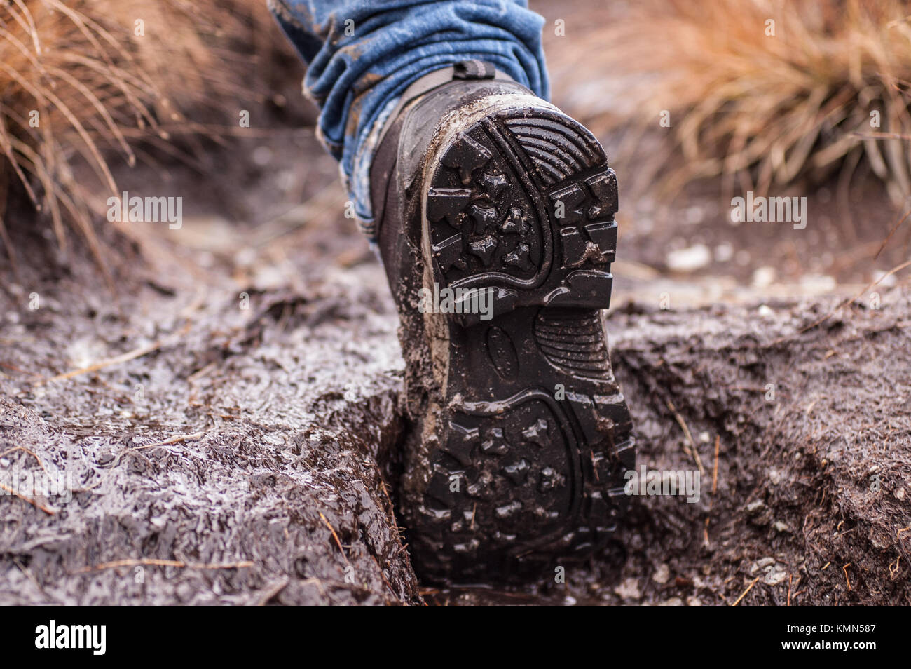 Suola di una singola calzatura Trekking coperto di fango preso mentre si cammina Foto Stock