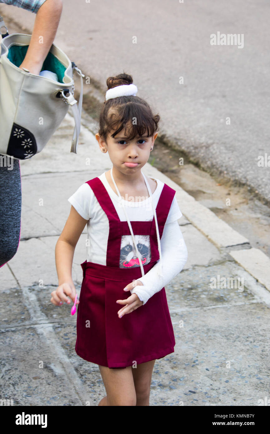 Ragazza giovane con un cast sul suo braccio a Cienfuegos, Cuba Foto Stock