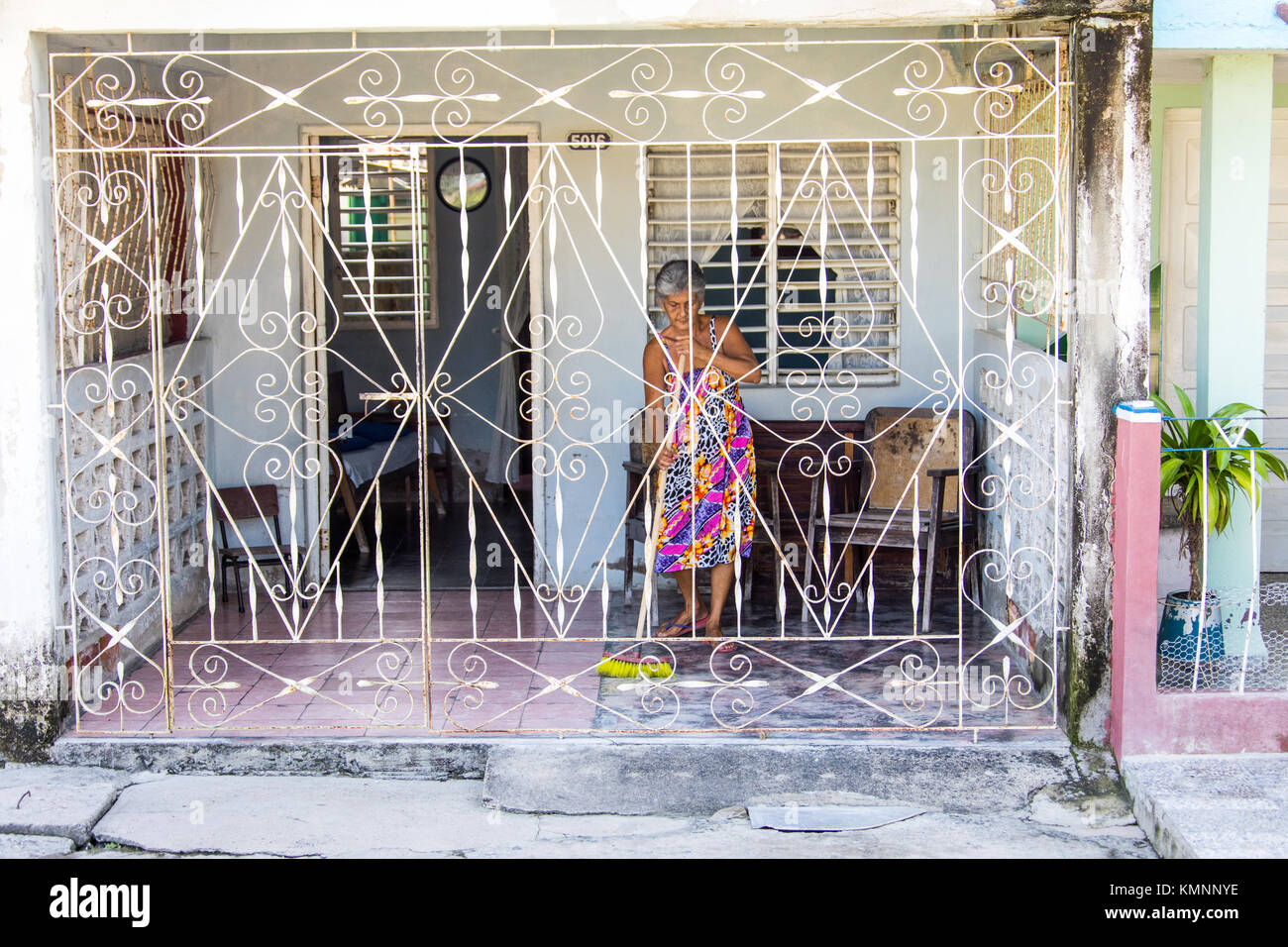 Donna anziana spazzare la sua casa di Cienfuegos, Cuba Foto Stock