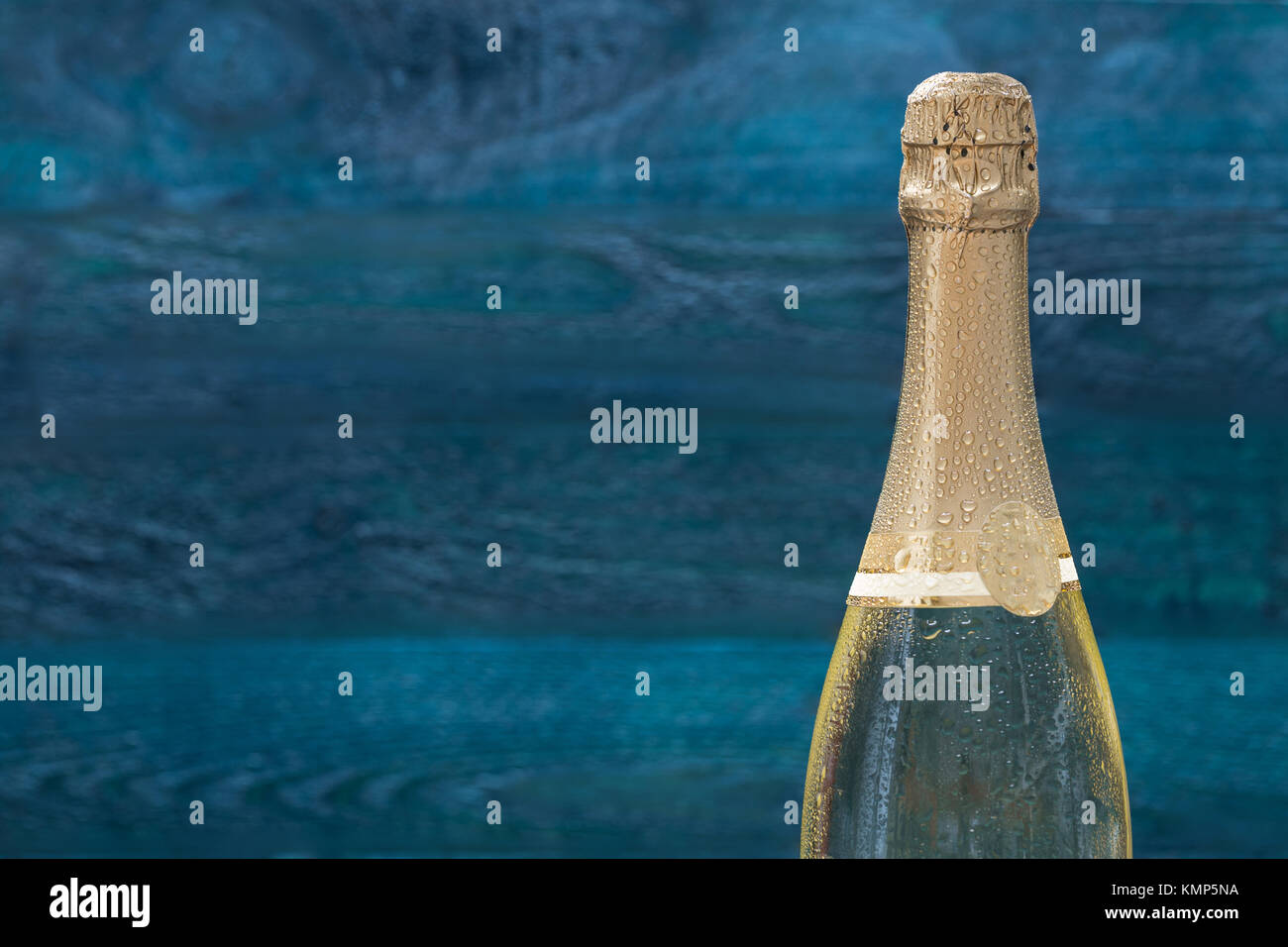 Bottiglia di Champagne con gocce di acqua contro una benzina-colore di sfondo. Foto Stock