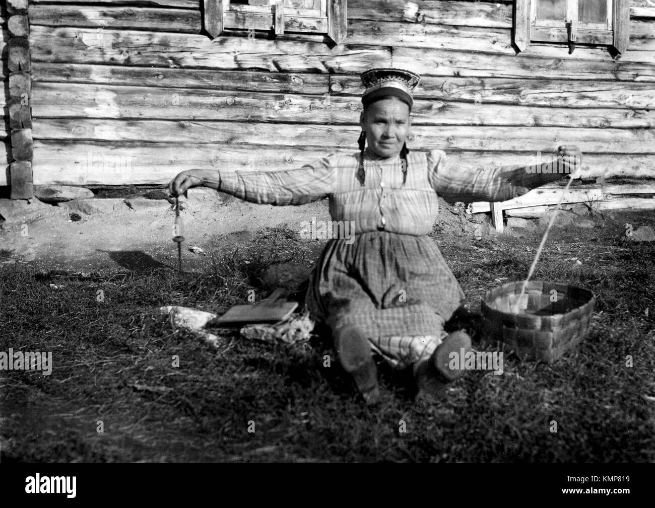 I vecchi donna Sami la filatura con mandrino, Finlandia Foto Stock