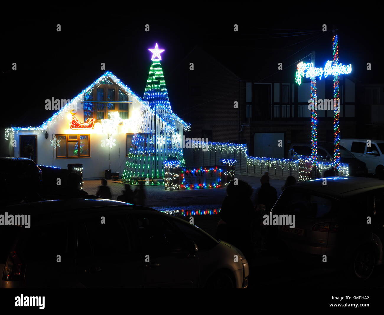 Warden Bay, Kent, Regno Unito. L'8 dicembre, 2017. Una casa in Warden Bay mette su una più imponenti le luci di Natale display provvisto di un albero di Natale più alto di casa formata da luci, che visualizza una gamma di computer modelli controllati. Ogni venerdì durante il mese di dicembre che conduce fino a Natale una breve visualizzazione è messo su per la gente del posto a 7pm, con le luci temporizzate per la musica. Anche su questa sera eccezionalmente fredda sera, circa 50 persone uscì a guardare. Il display è organizzato da Daniel e Kelly Arnott con donazioni per la carità. Credito: James Bell/Alamy Live News. Foto Stock