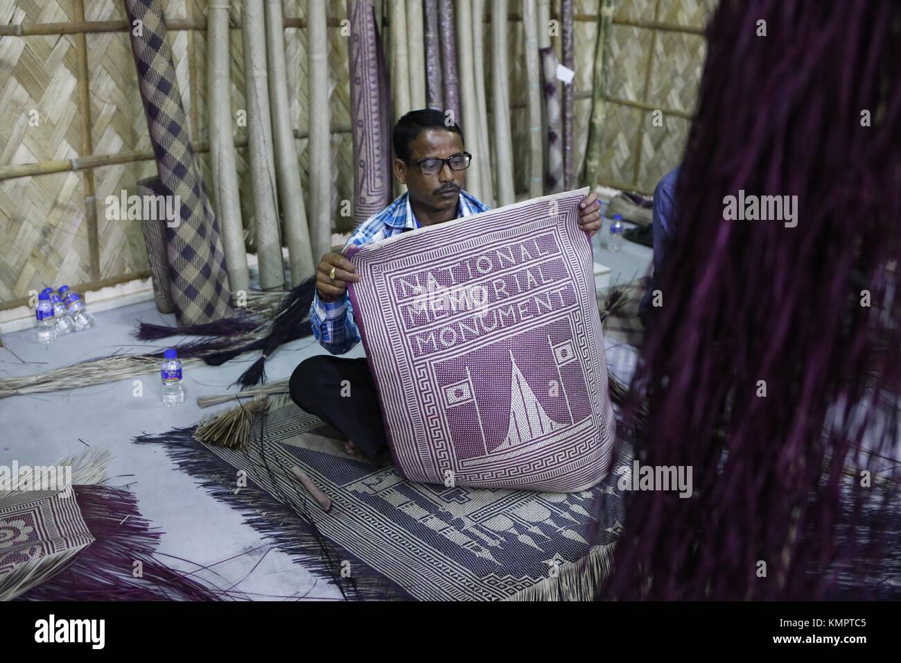 Dacca, Bangladesh. 9 dicembre 2017. Un artigiano mostra un pati Shital (un tappeto tradizionale fatto di materiali provenienti da piante murta) da consumare in una mostra su Shitol Pati presso il Museo nazionale del Bangladesh. Credito: M. Mehedi Hasan/ZUMA Wire/Alamy Live News Foto Stock