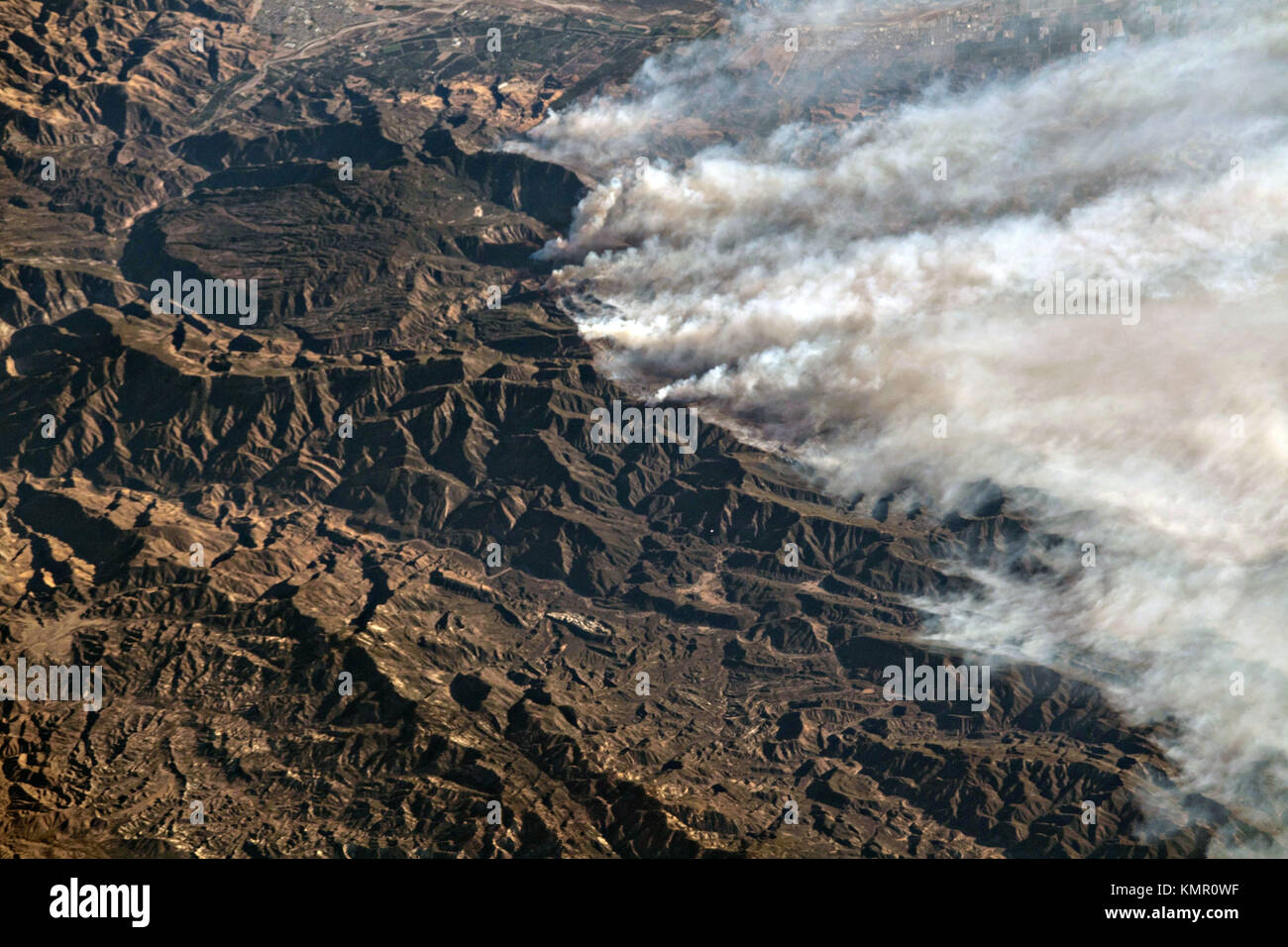 Il fumo da massicci fuochi bruciare tutta la California del sud visto dalla stazione spaziale internazionale il 6 dicembre 2017 in orbita intorno alla terra. Il thomas fuoco alimentato da gale force santa ana winds scolpito un cammino di distruzione dall'oceano pacifico a dieci miglia entroterra a sud lungo la costa di forzatura evacuazioni obbligatorie per decine di migliaia di residenti. Foto Stock