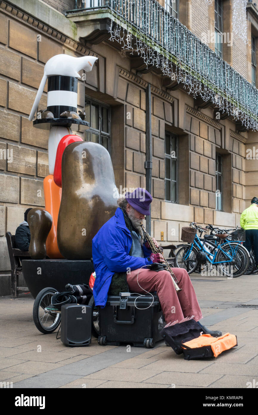 Busker suonare di fronte nevoso statua commemorativa Guildhall Market Square Cambridge Foto Stock