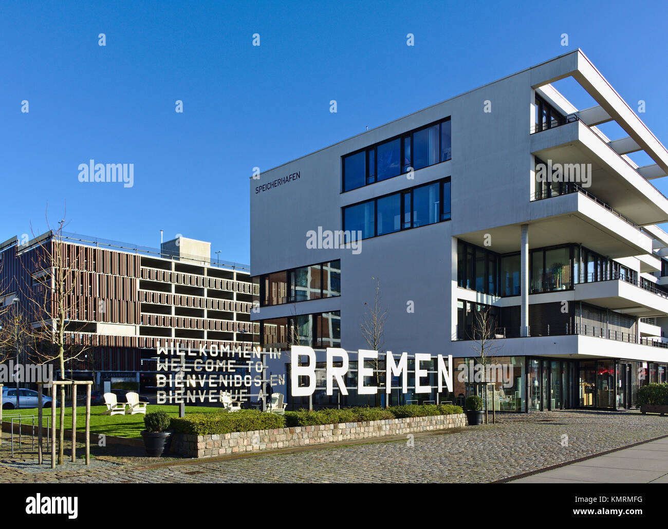 Bremen, Germania - Novembre 25th, 2017 - Spianata nel quartiere Überseestadt con cinque piani di un ufficio moderno edificio proprio accanto ad un grande cartello in metallo Foto Stock Bremen, Germania - Novembre 25th, 2017 - Spianata nel quartiere Überseestadt con cinque piani di un ufficio moderno edificio proprio accanto ad un grande cartello in metallo Foto Stock