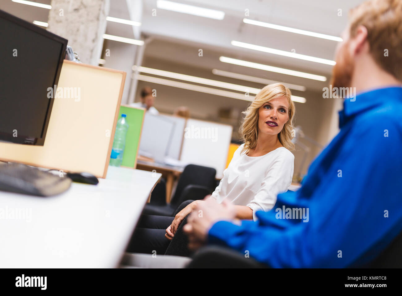 Bella bionda lavoratore parlando con un collega in ufficio Foto Stock
