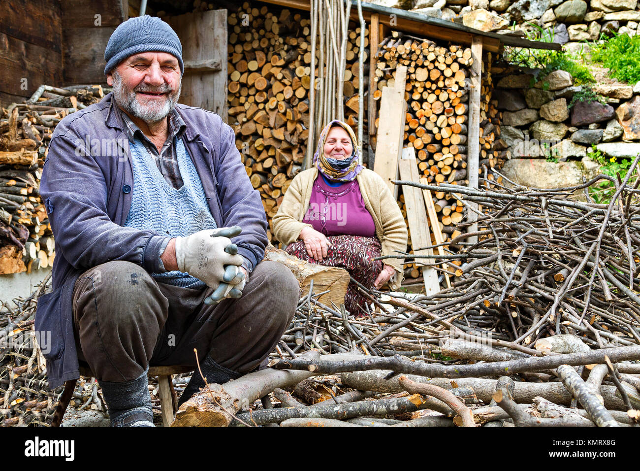 Anziana coppia turca sorridente e guardando mentre si trita il fuoco di legna a Trabzon, Turchia. Foto Stock