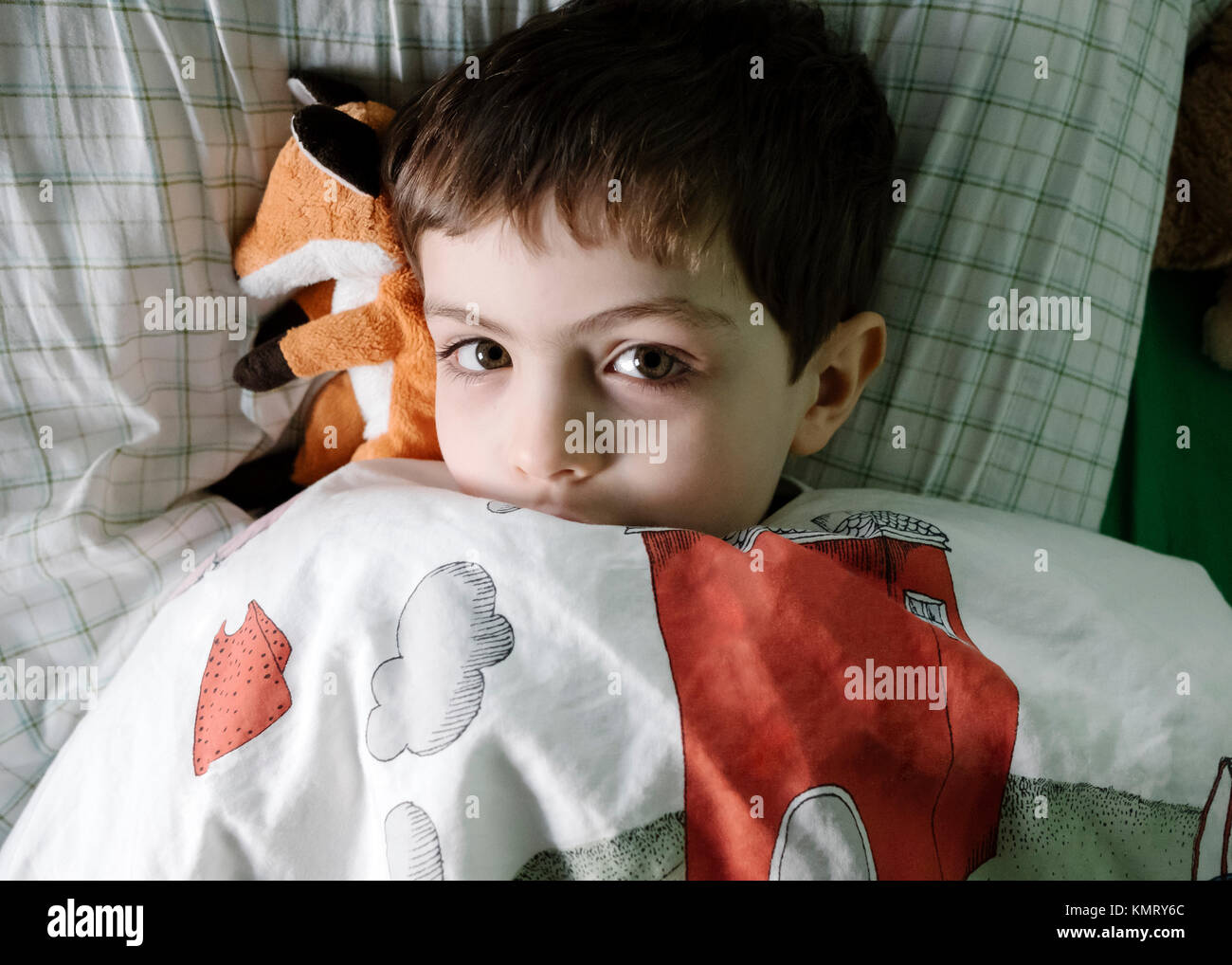 Ritratto di overhead del ragazzo disteso sul letto Foto Stock