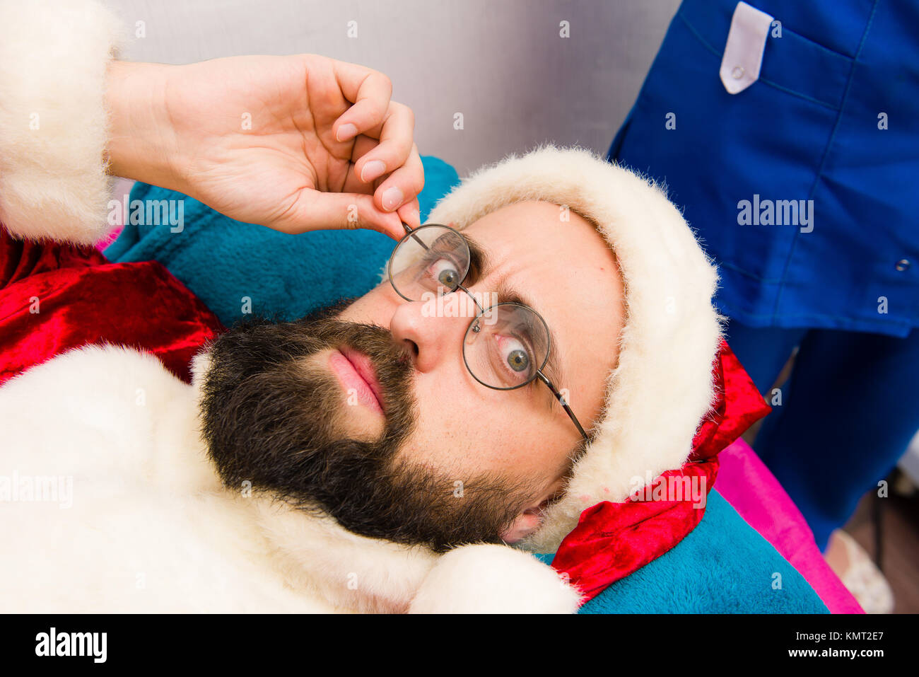 Spa maschera facciale applicazione. Uomo di natale di Santa Claus vestiti in beauty spa. Foto Stock