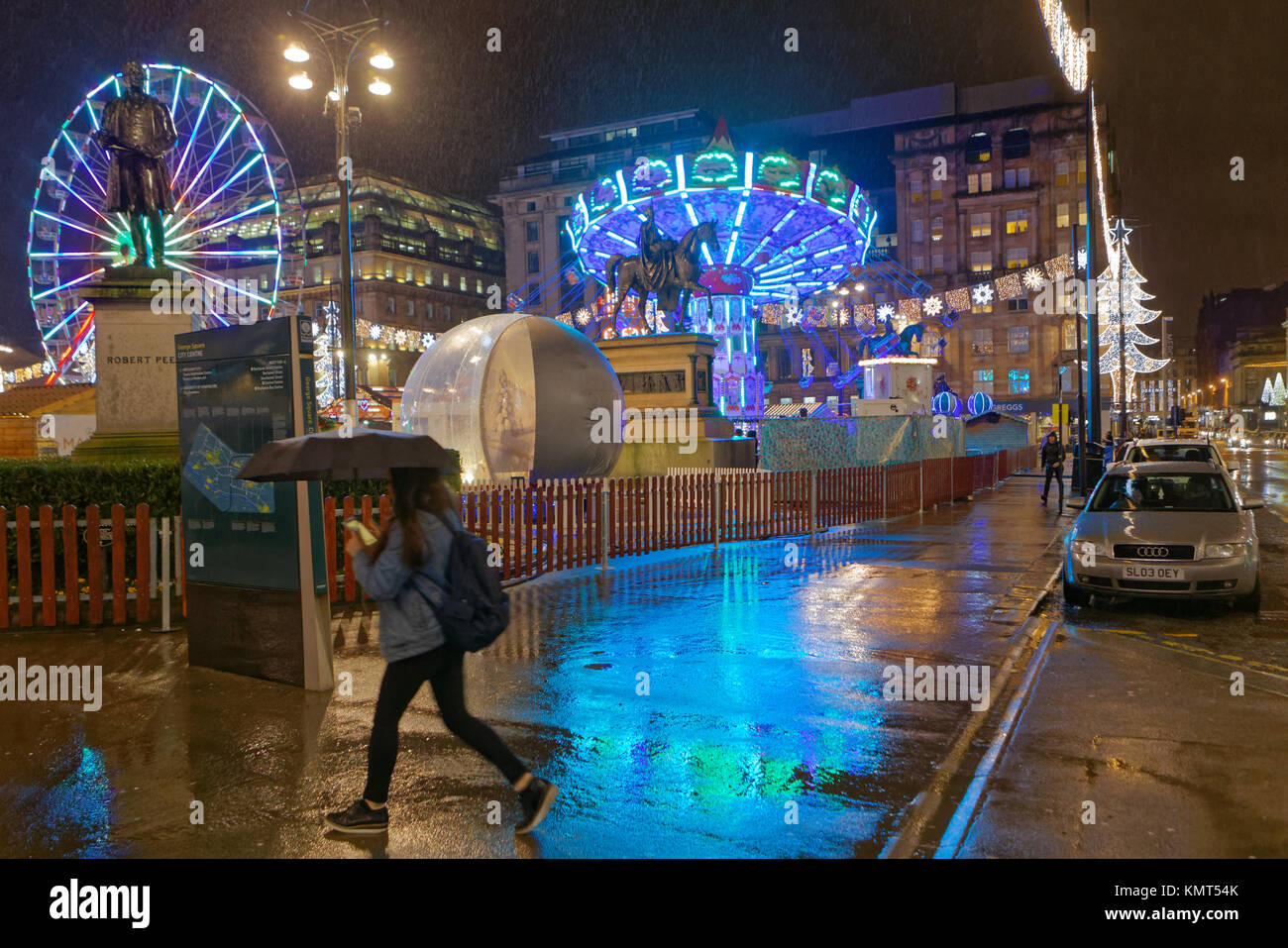 Piove ombrello piovosa ragazza camminare Street Glasgow ama la fiera di Natale fayre mercato intrattenimento carnevale George Square, Glasgow City Foto Stock