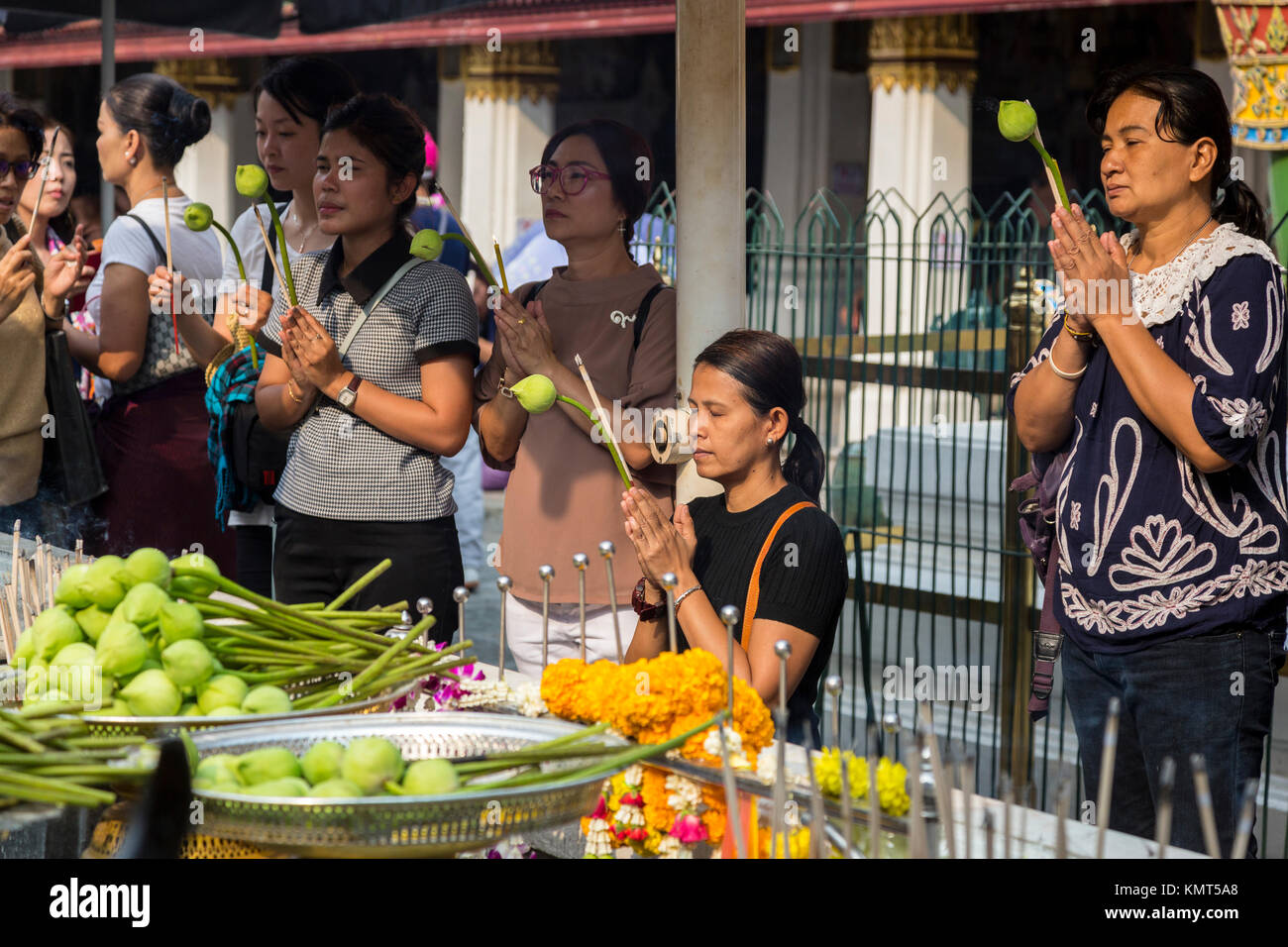 Bangkok, Tailandia. Adoratori di pregare presso la Royal Grand Palace Tenendo fiori di loto. Foto Stock