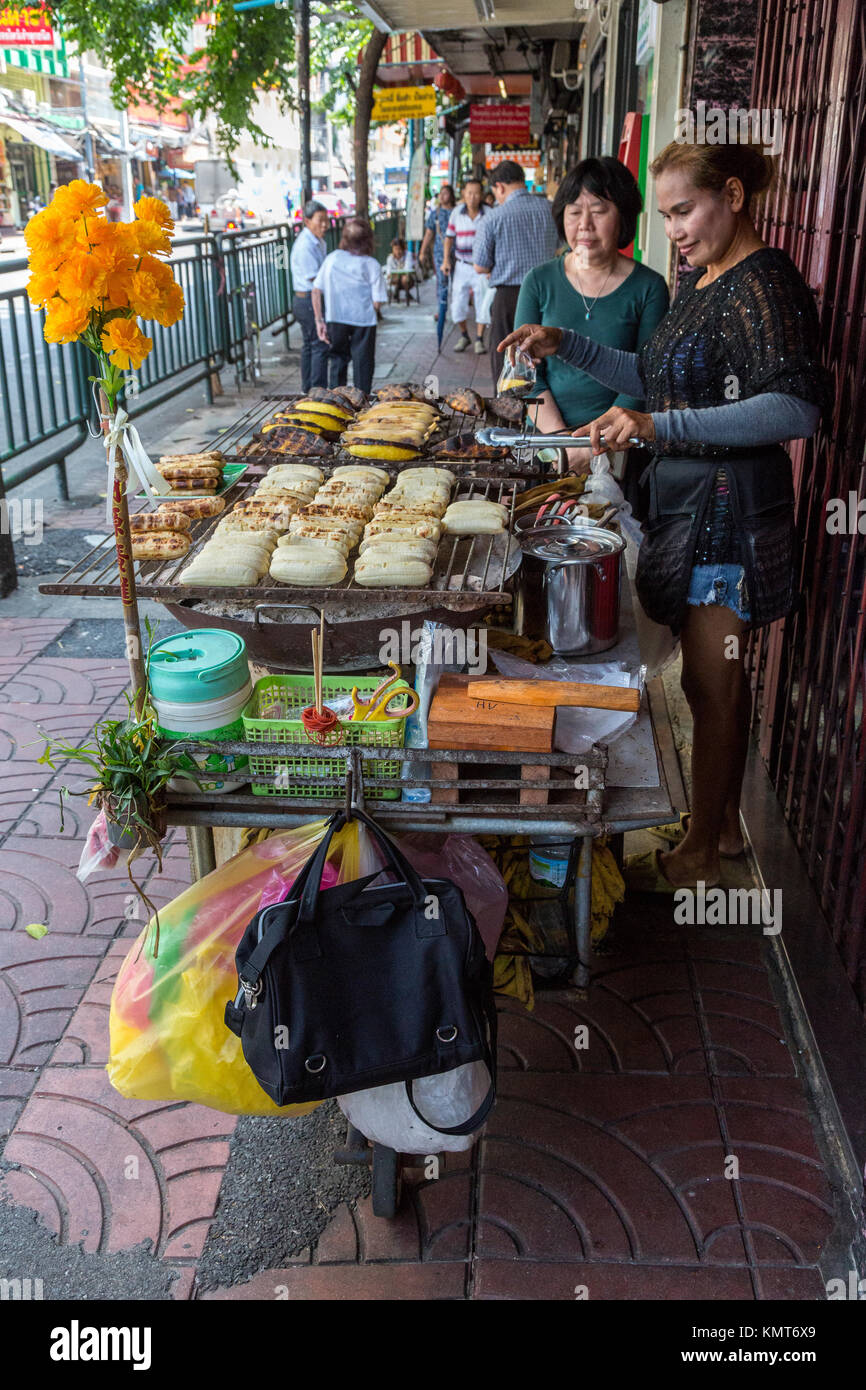 Bangkok, Tailandia. Cucina di strada venditore a vendere banane arrosto. Foto Stock