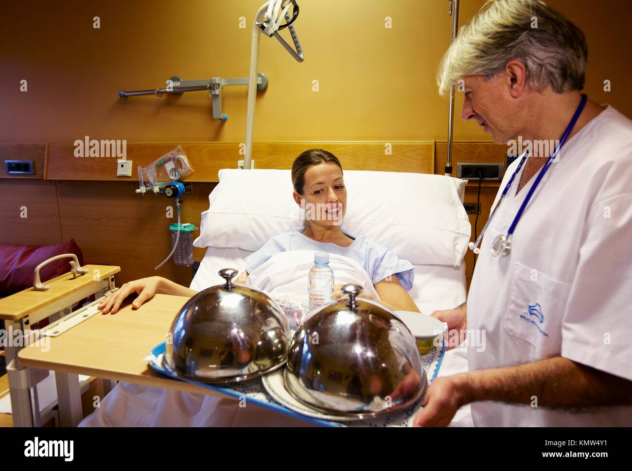 Infermiera con il vassoio per alimenti e il paziente in una stanza di  ospedale. Ospedale Policlinica Gipuzkoa, San Sebastian, Donostia, Euskadi,  Spagna Foto stock - Alamy