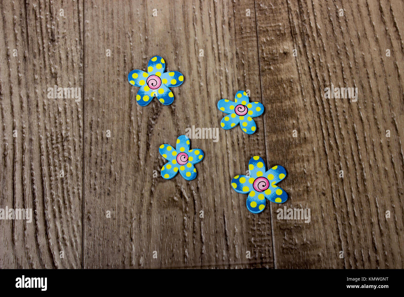 Cartoncino colorato taglio dei fiori la posa su una tavola di legno del pavimento della granella Foto Stock