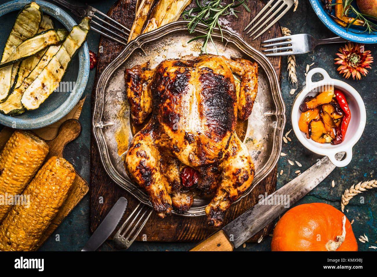 Arrostito intero tacchino o pollo con raccolta organica di verdure e zucca per cena di ringraziamento sul tavolo rustico sfondo, vista dall'alto Foto Stock