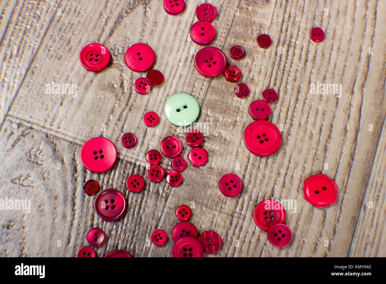 Colorate di rosso e verde sfondo pulsanti pulsanti, recante su una tavola di legno del pavimento della granella Foto Stock