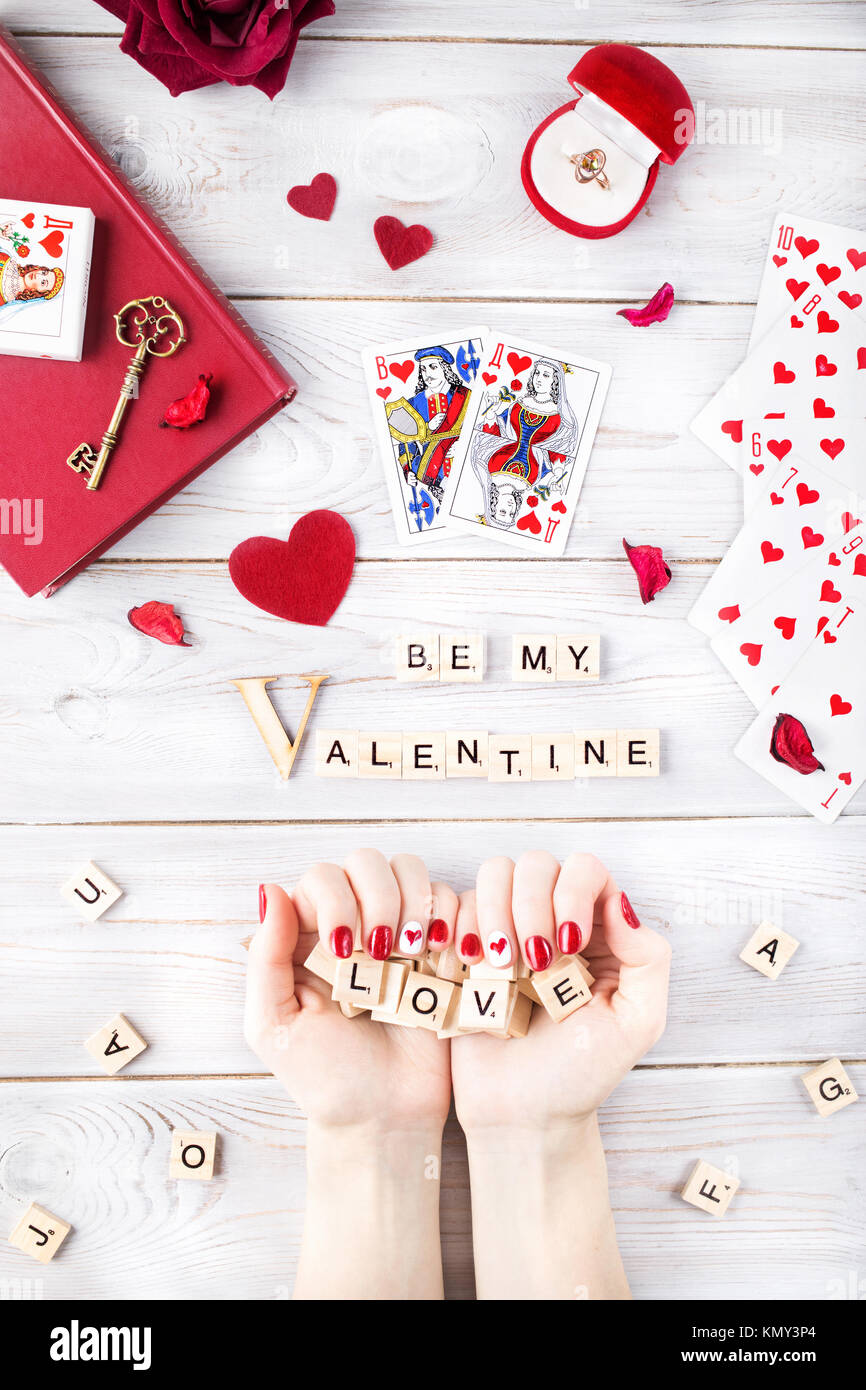 Mosca, Russia - FEBRURARY 19, 2017: illustrativi immagine editoriale del giorno di San Valentino romantico concetto. Donna con unghie rosse azienda parola amore da legno Foto Stock