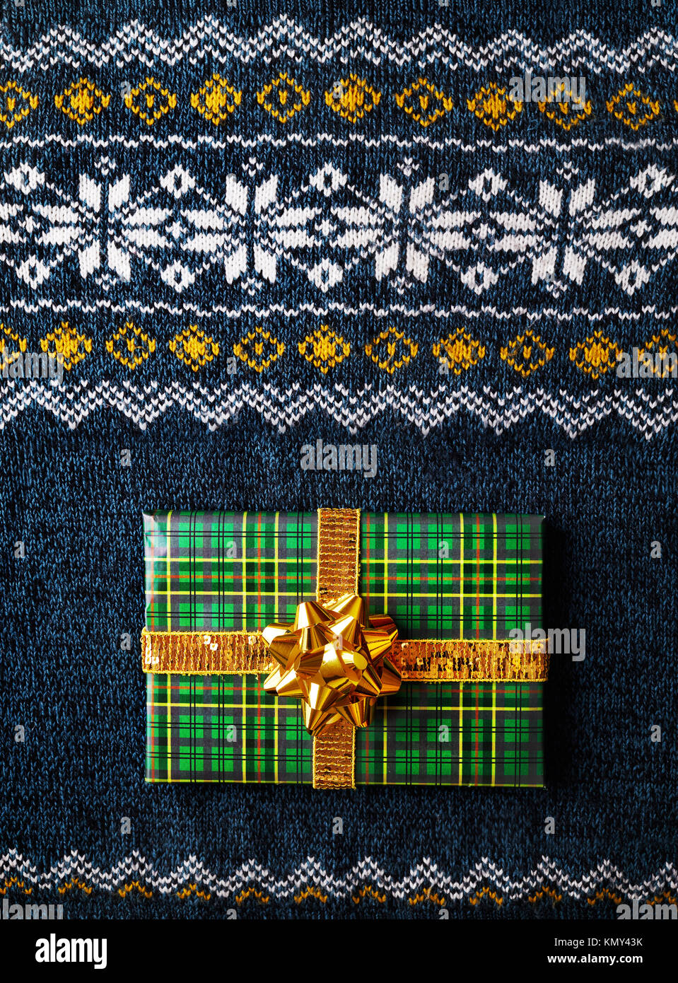 Verde presente avvolto con golden bow sull uomo maglione a tempo di Natale Foto Stock