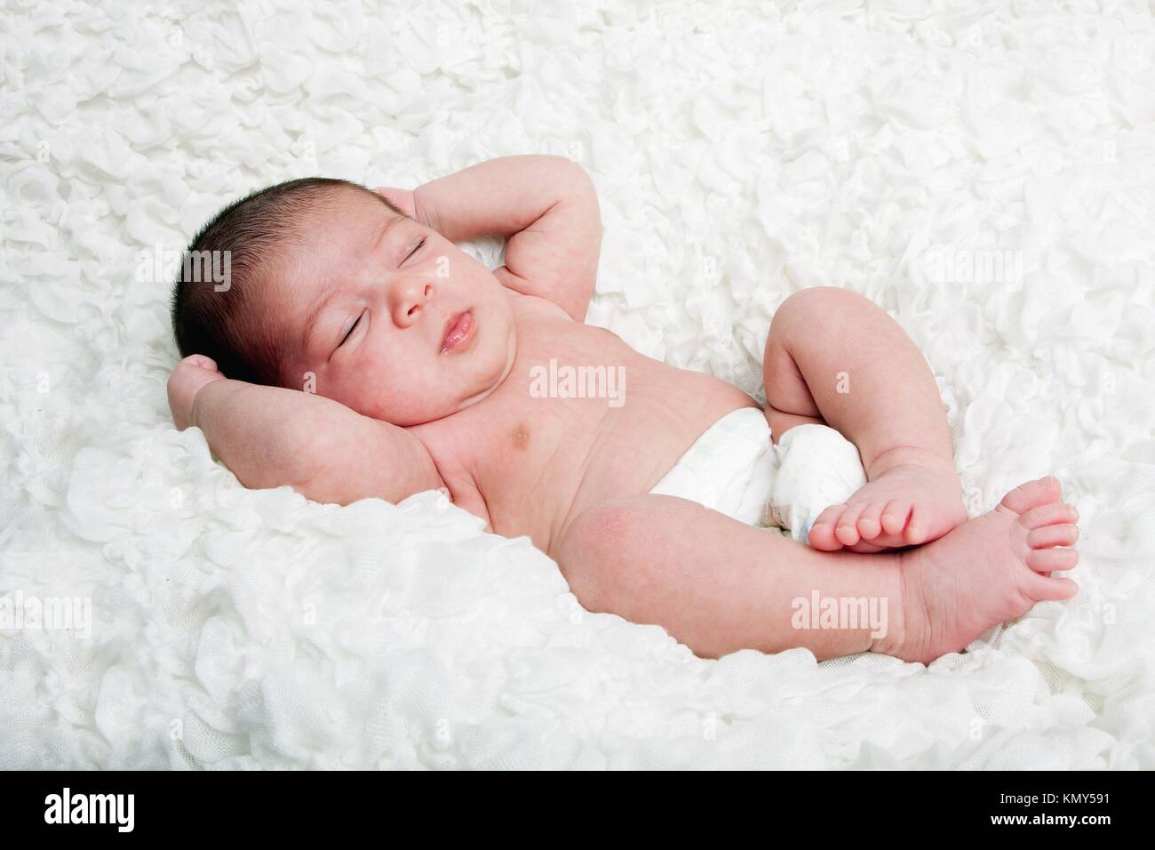 Carino ispanica caucasica neonato Bambino addormentato in morbido cotone  bianco cloud, indossando solo un pannolino Foto stock - Alamy