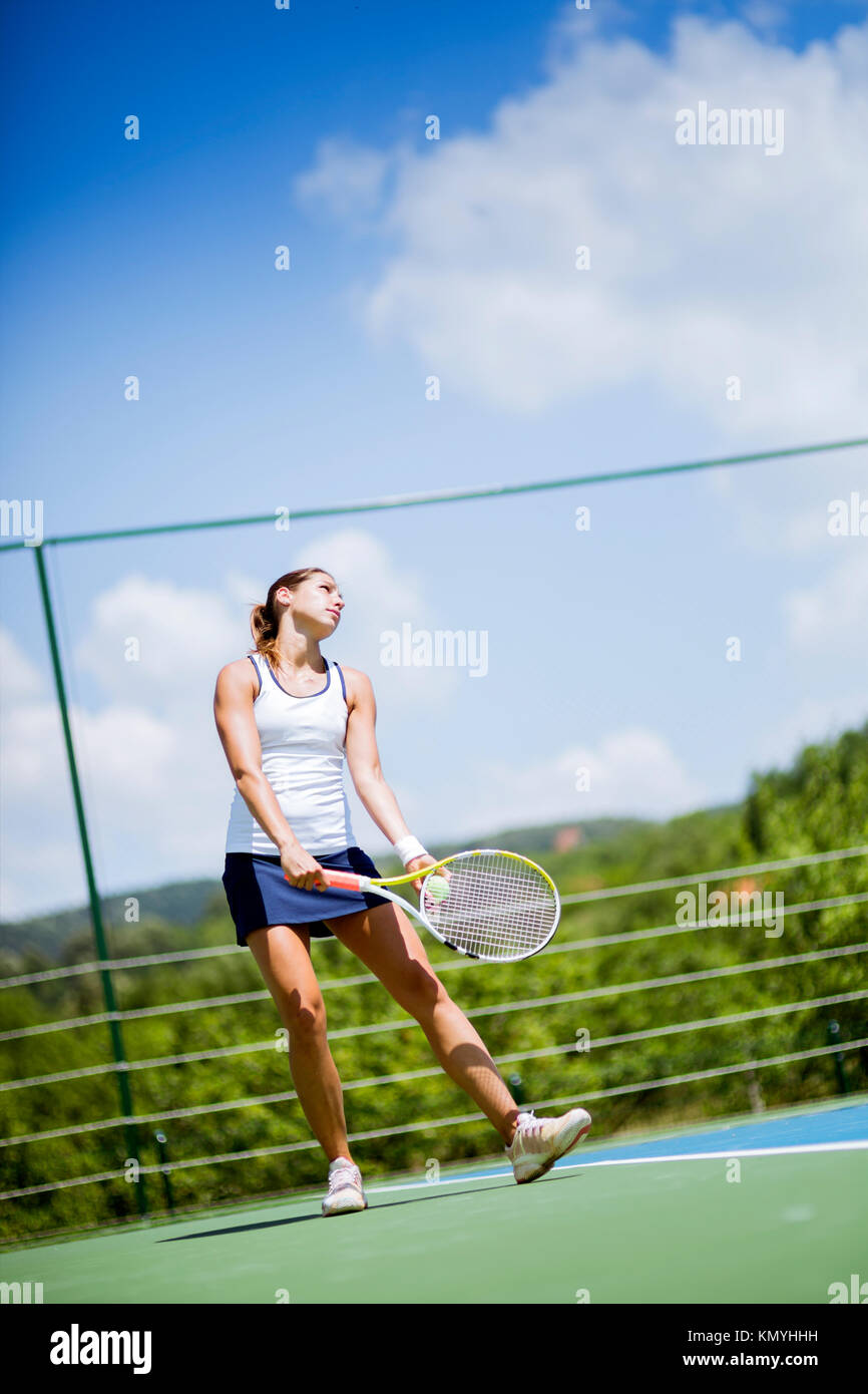 Bellissima femmina giocatore di tennis che serve Foto Stock